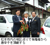 写真：松本市内の地区巡りで有権者から唐辛子を頂戴する
