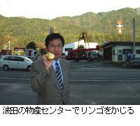 写真：波田の物産センターでリンゴをかじる