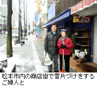 写真：松本市内の商店街で雪片づけをするご婦人と