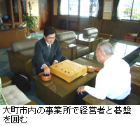 写真：大町市内の事業所で経営者と碁盤を囲む