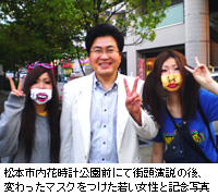 写真：松本市内花時計公園前にて街頭演説の後、変わったマスクをつけた若い女性と記念写真