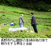 写真：長野市内山間部の急傾斜地の畑で耕作をする男性と会話