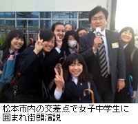 写真：松本市内の交差点で女子中学生に囲まれ街頭演説