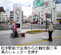写真：松本駅前で台湾からの観光客に写真のシャッターを押す