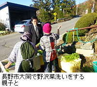 写真：長野市大岡で野沢菜洗いをする親子と