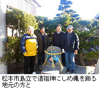 写真：松本市島立で道祖神にしめ縄を飾る地元の方と