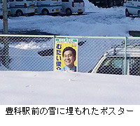 写真：豊科駅前の雪に埋もれたポスター