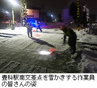 写真：豊科駅南交差点を雪かきする作業員の皆さんの姿