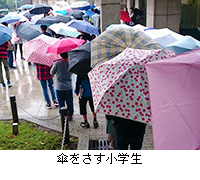 写真：傘をさす小学生