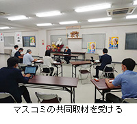 写真：マスコミの共同取材を受ける
